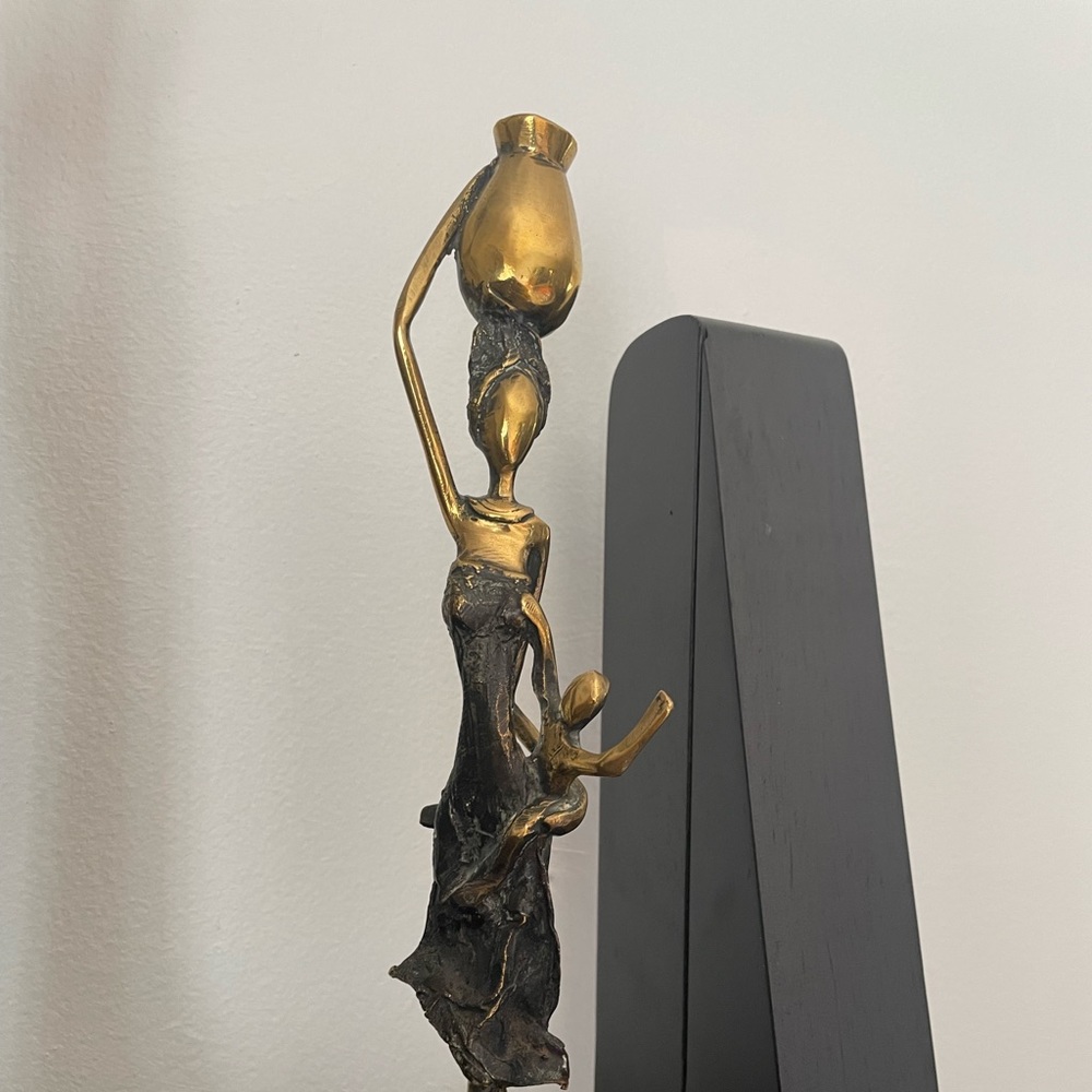 Sculpture of a woman carrying child and bucket
